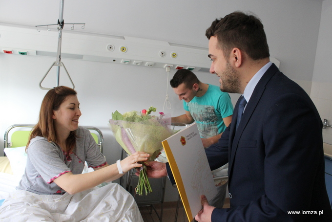 Prezydent Łomży Mariusz Chrzanowski przekazuje bukiet kwiatów mamie noworodka Ewelinie Stypułkowskiej
