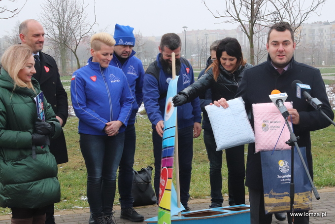 prezydent Łomży Mariusz Chrzanowski prezentuje dziecięce kocyki, przekazane na licytację WOŚP