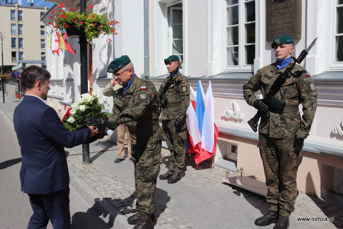 zastępca prezydenta Łomży Andrzej Garlicki składa kwiaty przed tablicą Marszałka Józefa Piłsudskiego znajdującą się na Domku Pastora